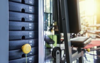 Close up on weight machine stack with Tendo Unit sensor string, by Tendo Sport, being attached to