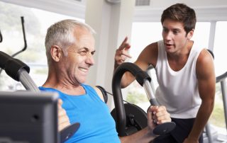 Middle Aged Man Being Encouraged By Personal Trainer In Gym while training with Tendo Sports machines and technologies