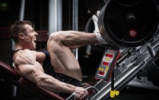 Strong man athlete training his legs on leg press while measuring his velocity for velocity based training via Tendo Unit by Tendo Sport