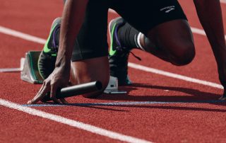 A runner is waiting for the start signal on a running track - Tendo Sport