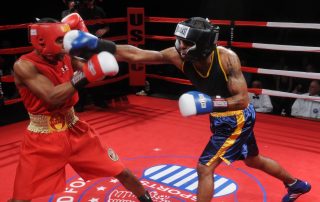 Two boxers fighting in a boxing match while one of the is punching the other in the face - Tendo Sport