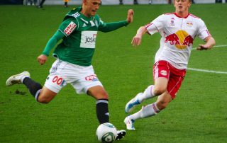 football players fighting over a ball during a match - Tendo Sport