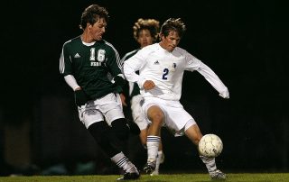 man soccer players fighting over the ball - Tendo Sport