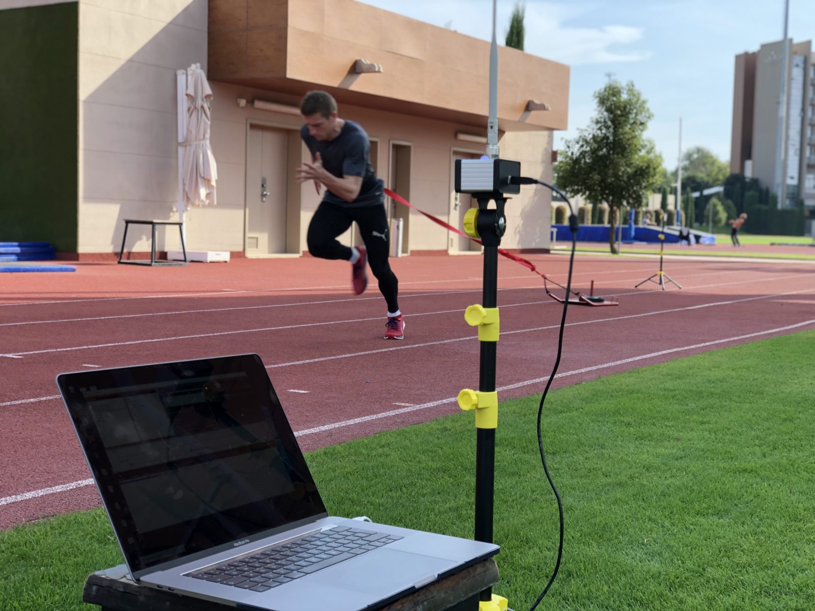 Athlete training sprints on track while his speed in measured with Tendo Sprint System by Tendo Sport