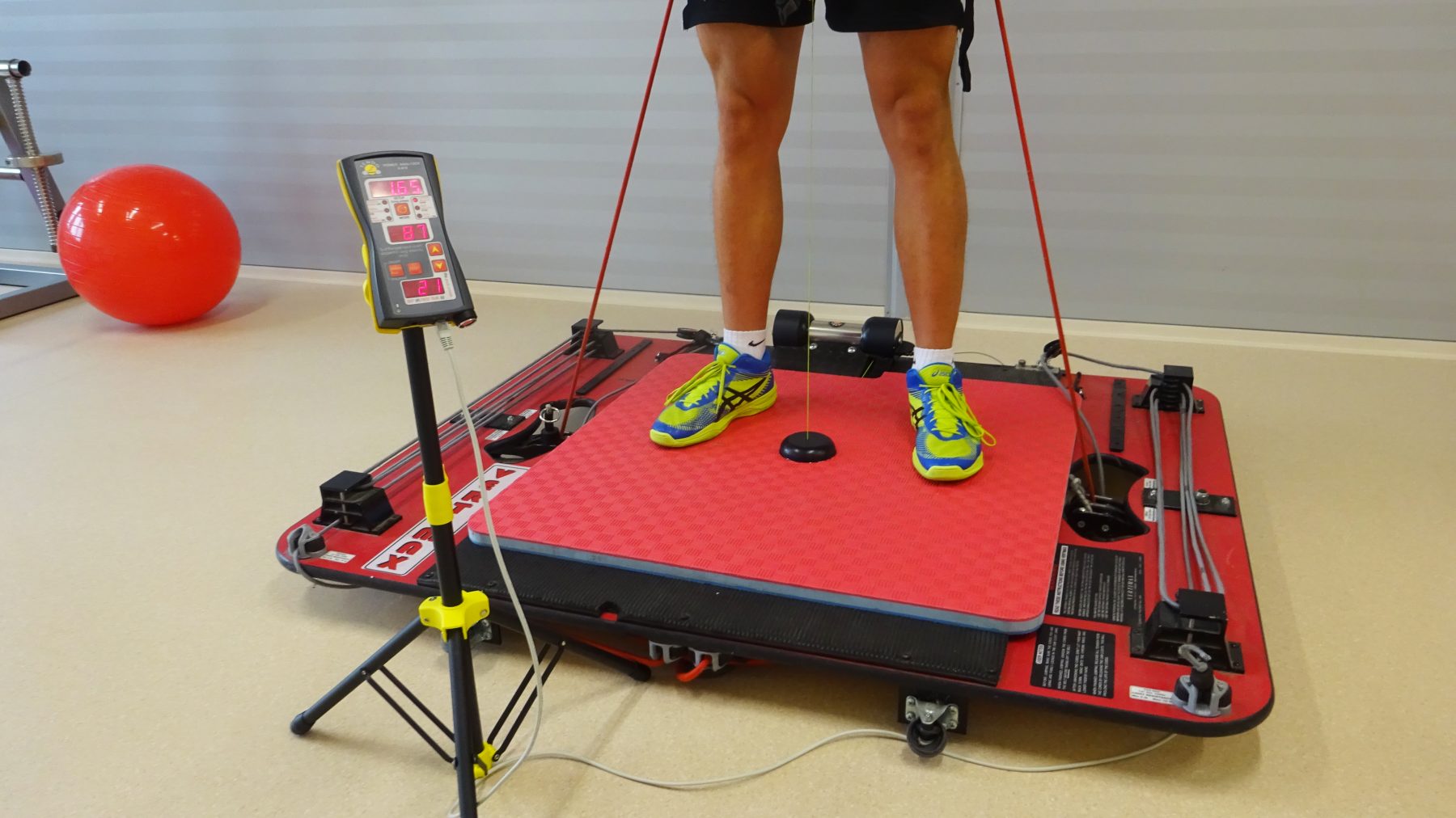 Athlete performing jumps with Vertimax. Measuring power and velocity of legs using Tendo Unit and Tendo JumpMat with detail On Tendo microcomputer unit